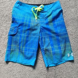 Boy's Under Armour board shorts, blue and with neon yellow stripes.
